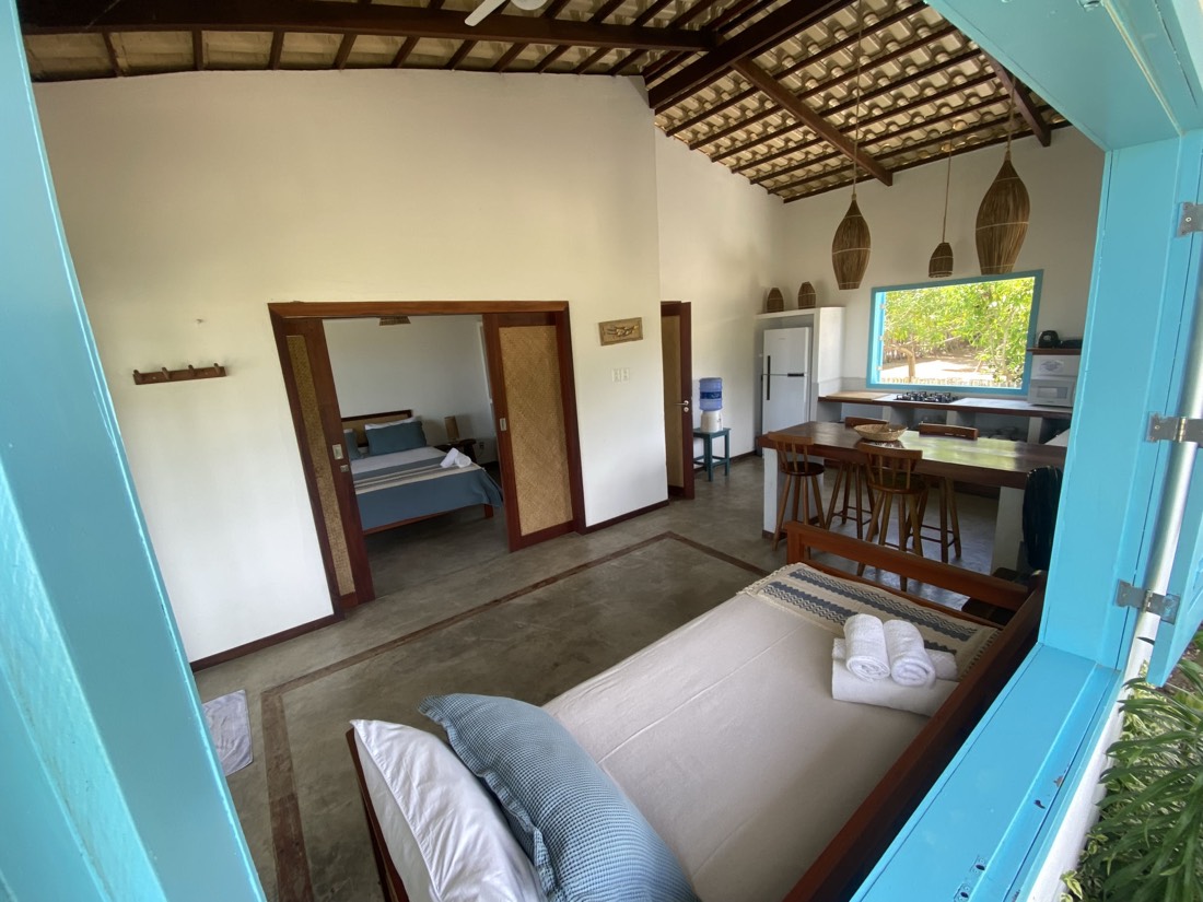 Sala de estar integrada à cozinha da Casa Vento, com sofá-cama